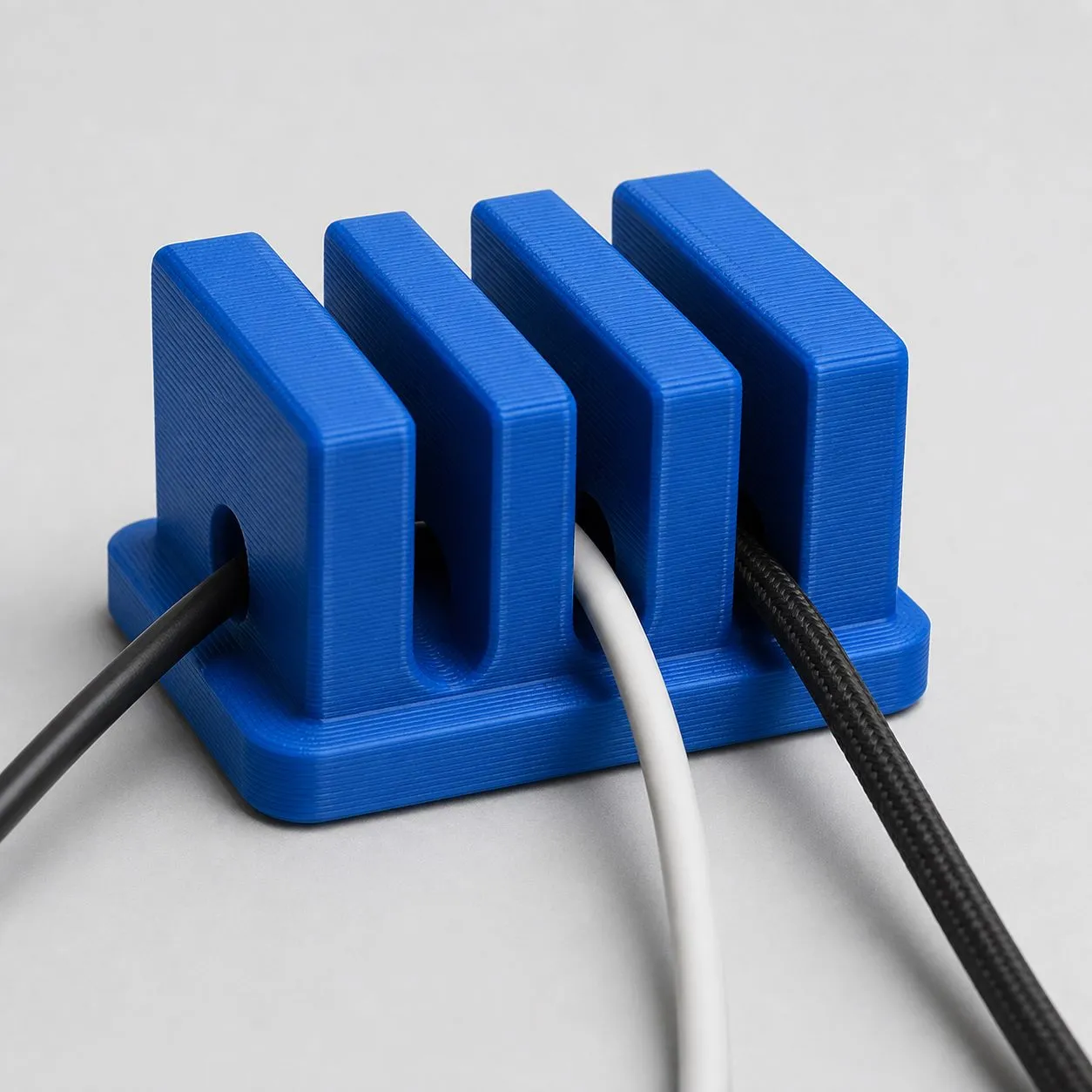 Cable organizer biru dengan tekstur layer hasil cetak FDM